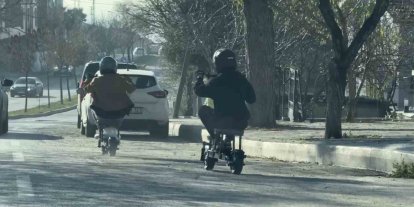 TRAFİKTE İLGİNÇ ANLAR: TABURENİN ÜZERİNE OTURARAK ELEKTRİKLİ SCOOTER KULLANDILAR